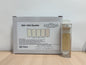 A box of R2A / R2A Dipslide with a clear cylindrical sample vial containing a beige liquid, placed on a light wood surface against a plain white wall.